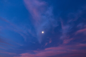 Fototapeta na wymiar 朝焼けの空に浮かぶ満月