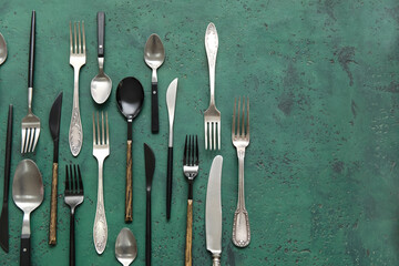 Many different cutlery on green background, top view