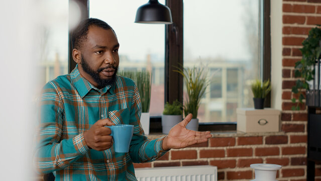 Young man teaching drawings skills to creative people attending artistic workshop. Educational program to develop new skills and learn to draw sketch on white canvas. Handheld shot