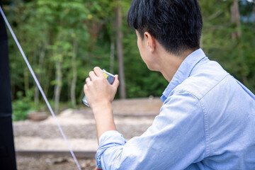 テントの下で缶ビールを飲む男性　BBQ