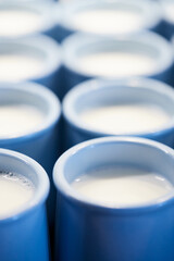 Jars of milk ready for ripening and turning into yogurt. The process of producing homemade yogurt. Vertical photo.