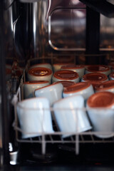 The process of washing yogrut jars in the dishwasher. Homemade yogurt making. Vertical photo.
