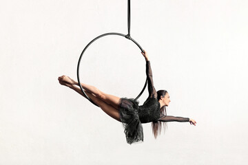 Flexible woman doing exercise on aerial hoop