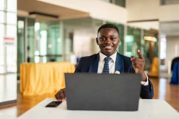 Fototapeta na wymiar Portrait of handsome African businessman using laptop computer