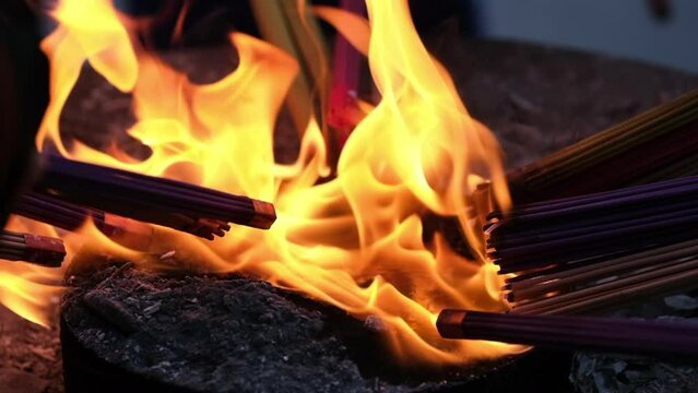 close up putting joss sticks on fire. Burn incense. Asian religious concept. Super slow motion