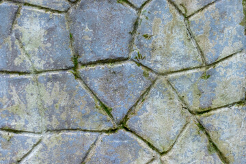 A fragment of a wall made of chipped stone and a small amount of moss. Natural background