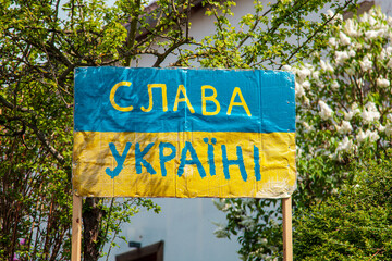 Ukrainian Text Banner слава Украина in front yard - Glory to Ukraine and nature...