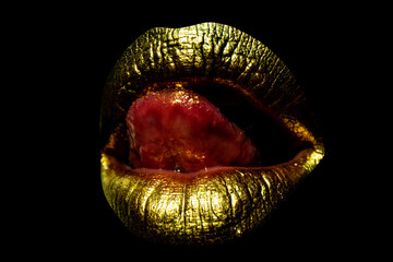 Sensual golden woman lips. Womans gold lip. Female mouth close up with golden lipstick. Woman tongue licking sexy lips.