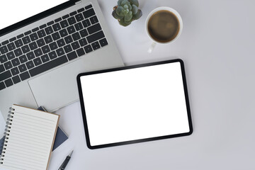 Digital tablet, laptop, notebook, succulent plant and coffee cup on white office desk. Top view.