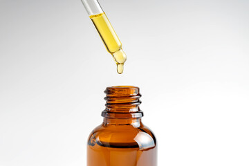 Pipette with falling drop of oil. Dropper with lotion, essence, serum, emulsion. Natural organic cosmetic. Body care concept