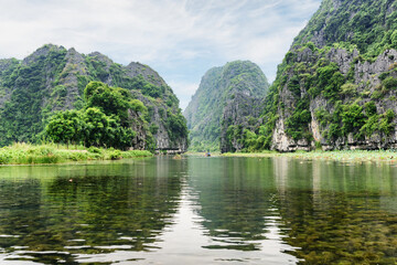 Fototapeta na wymiar Natural karst towers reflected in the Ngo Dong River, Vietnam