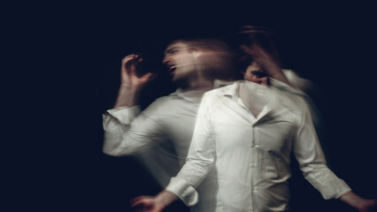 man with mental disorders and schizophrenic disease in white shirt on dark background