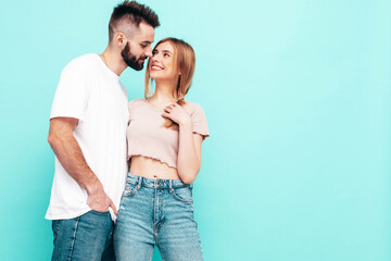 Fototapeta premium Sexy smiling beautiful woman and her handsome boyfriend. Happy cheerful family having tender moments near blue wall in studio.Pure cheerful models hugging.Embracing each other. Cheerful and happy