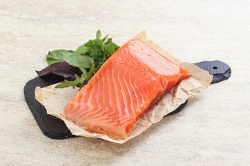 Raw salmon fillet over board