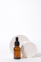 Beauty collagen face oil in a glass dropper bottle with podium. Trendy shoot of cosmetics packaging. Essential oil with natural ingredients.