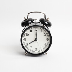 black vintage style alarm clock isolated on a white background