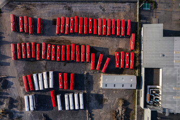 Aerial drone view on bus parking and repair garage. Raw with red color coaches and service building. Top down view.