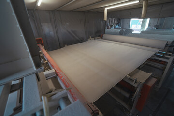 Machine that produces paper from recycled waste paper into large rolls. Manufacture of toilet paper and other paper products in factory.