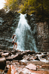 woman traveler enjoying view of waterfall