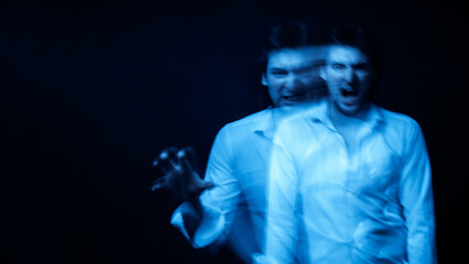 man with mental disorders and schizophrenic disease in white shirt on dark background