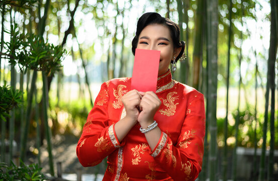 Asian pretty Chinese woman dress traditional cheongsam holding red envelope