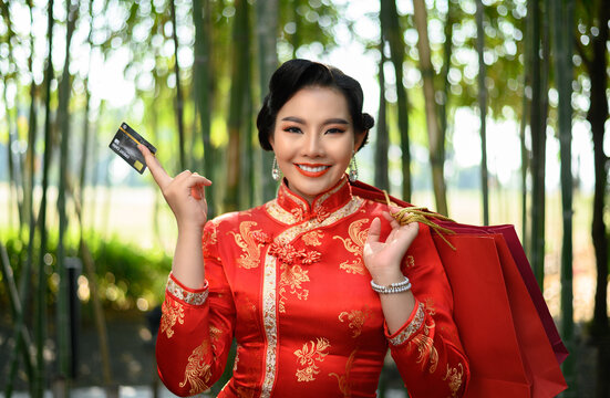 Asian pretty Chinese woman dress traditional cheongsam holding shopping bag with credit card