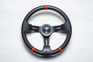 Sport car steering wheel and boost pressure sensor on the white flat lay table background.