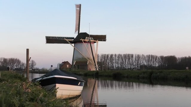 Dutch mill and boat alongside small canal in Schipluiden, the Netherlands