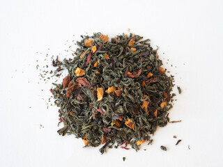 Green tea with herbs scattered on white