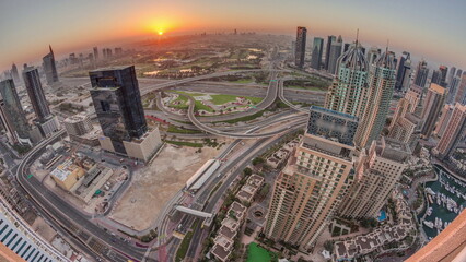 Sunrise over Dubai marina and JLT skyscrapers along Sheikh Zayed Road aerial timelapse.