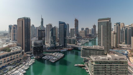 Fototapeta na wymiar Panorama showing aerial view to Dubai marina skyscrapers around canal with floating boats timelapse