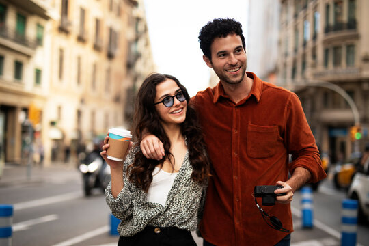 Traveling couple taking photos with camera. Loving couple walking through the city.