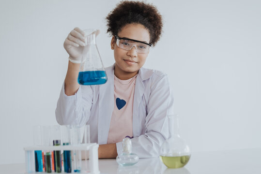 African american girl student learning a chemical experiment in science class. Happy african girl learning and doing chemical lab.