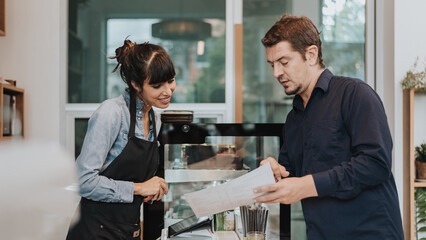 Caucasian woman barista take order from customer in coffee shop. female barista using digital tablet to take order. Coffee owner concept.
