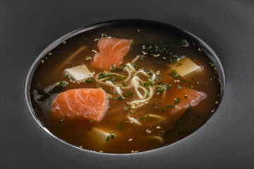 Soup with red fish, Asian cuisine. Photo of food on a dark background