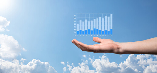 Business man holding tablet and showing holographic graphs and stock market statistics gain profits. Concept of growth planning and business strategy. Display of good economy form digital screen.