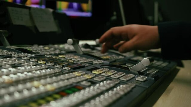 Broadcast Tv Studio Production - Vision Switcher Studio Director broadcast video mixer operation - Close-up of hand. Hands of a cinematographer who worked on the vision mixer, switch the TV panel.