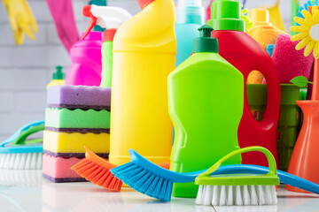 Spring house cleaning. Colorful cleaning kit on white wall background.
