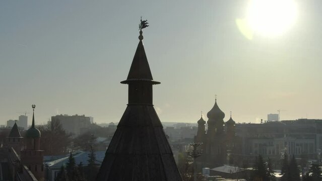 The wooden tower of an ancient castle against the background of the domes of the Tula temple and modern buildings.