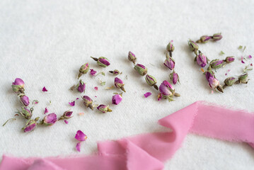 The word "love" is lined with dry rose flowers.