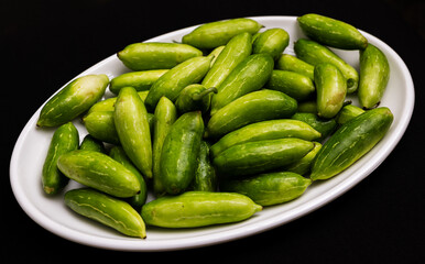 raw ivy gourd (kovakkai) in white plate