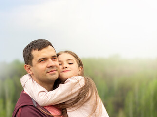 father and daughter hugging outdoors close-up