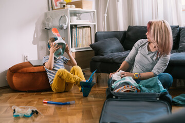 Obraz premium single mother and her son preparing bags for summer vacation