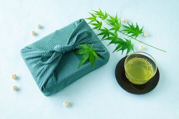 緑のモミジと水引玉と風呂敷包みと冷たい緑茶（ブルーバック）