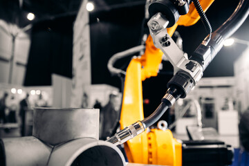 Fototapeta premium CNC automatic arm robot welding metal pipe part in industry factory