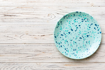 Top view of empty blue plate on wooden background. Empty space for your design.