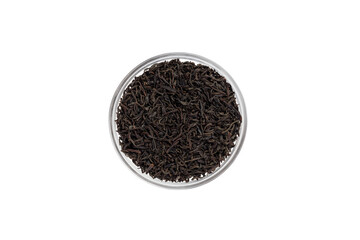 Black tea dry leaves in a glass bowl isolated on white background, top view.