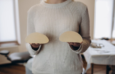 Portrait of female doctor choosing mammary prosthesis in the office.