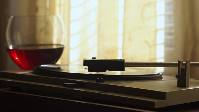 Vintage 1960's Home Scene, Vintage Gramophone Needle on Vinyl Record and Glass of Red Wine by Window and Curtains