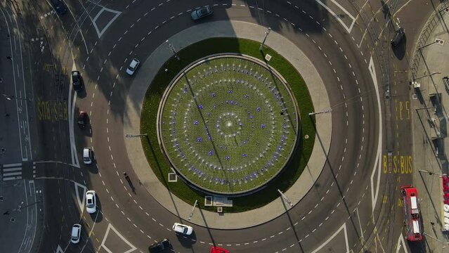 Top Down Aerial View of Roundabout Traffic in Metropolis, Cars and Public Transportation, Spinning High Angle drone Shot
